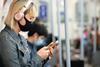 Passenger using mobile device on London Underground train (Photo TfL)